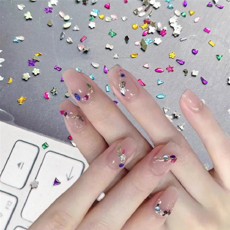 DIY luxury nail accessories set with colorful rhinestones on natural toned nails and scattered decorations